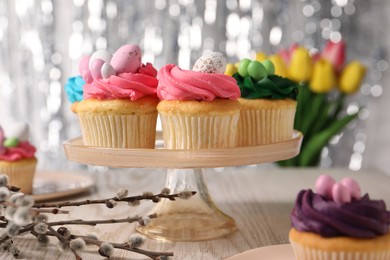 Photo of Tasty cupcakes with Easter decor on wooden table