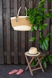 Photo of Different stylish beach accessories near wooden fence outdoors