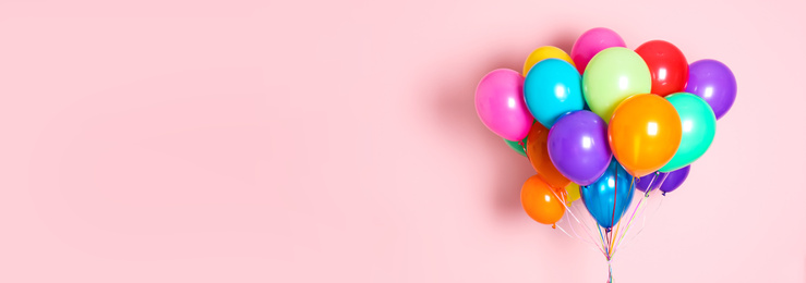 Image of Bunch of bright balloons on pink background, space for text. Banner design 