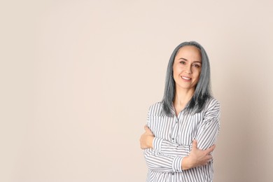 Portrait of smiling woman with ash hair color on beige background. Space for text