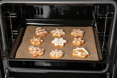 Baking tray with tasty Christmas cookies in oven