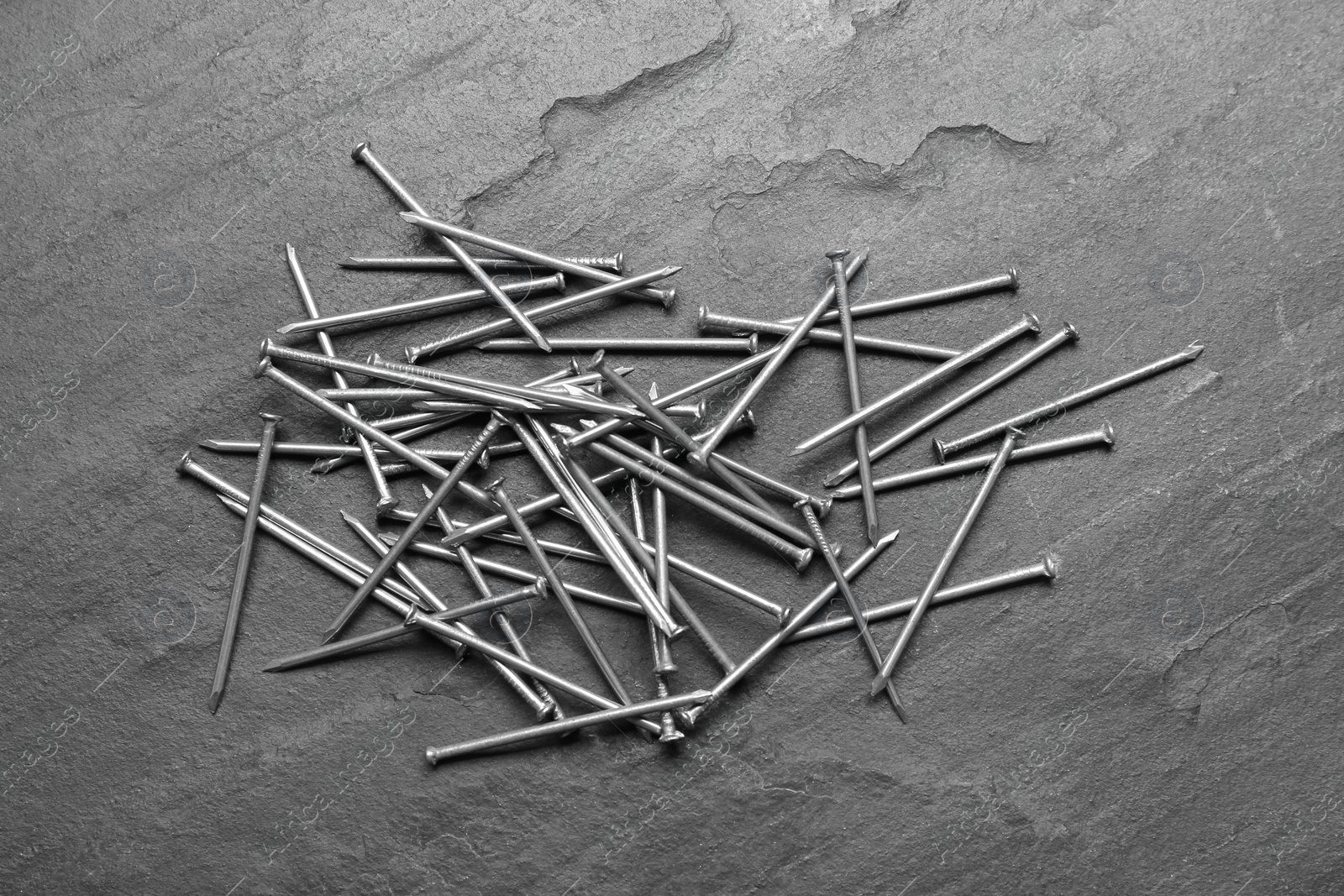 Photo of Many metal nails on grey background, flat lay