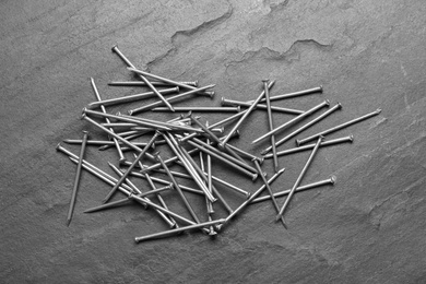 Photo of Many metal nails on grey background, flat lay