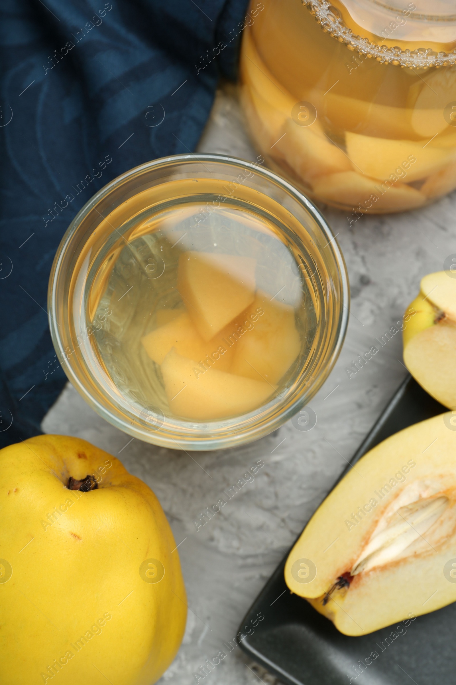 Photo of Delicious quince drink and fresh fruits on grey table, flat lay