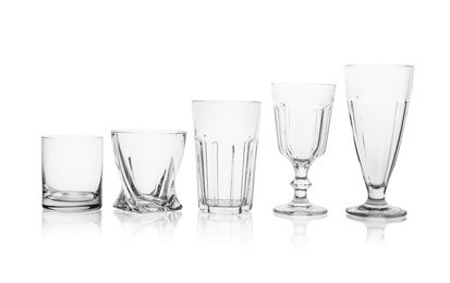 Photo of Set of empty glasses for different drinks on white background