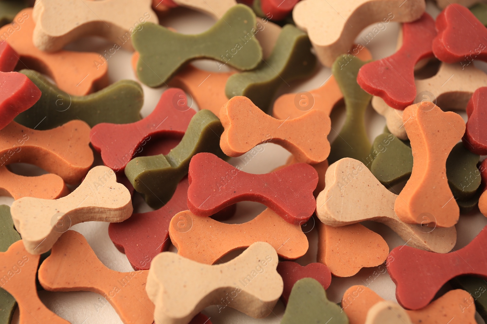Photo of Many bone shaped vitamins for pets as background, closeup
