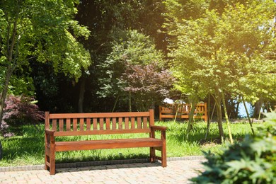 Photo of Stylish wooden bench in park on sunny day