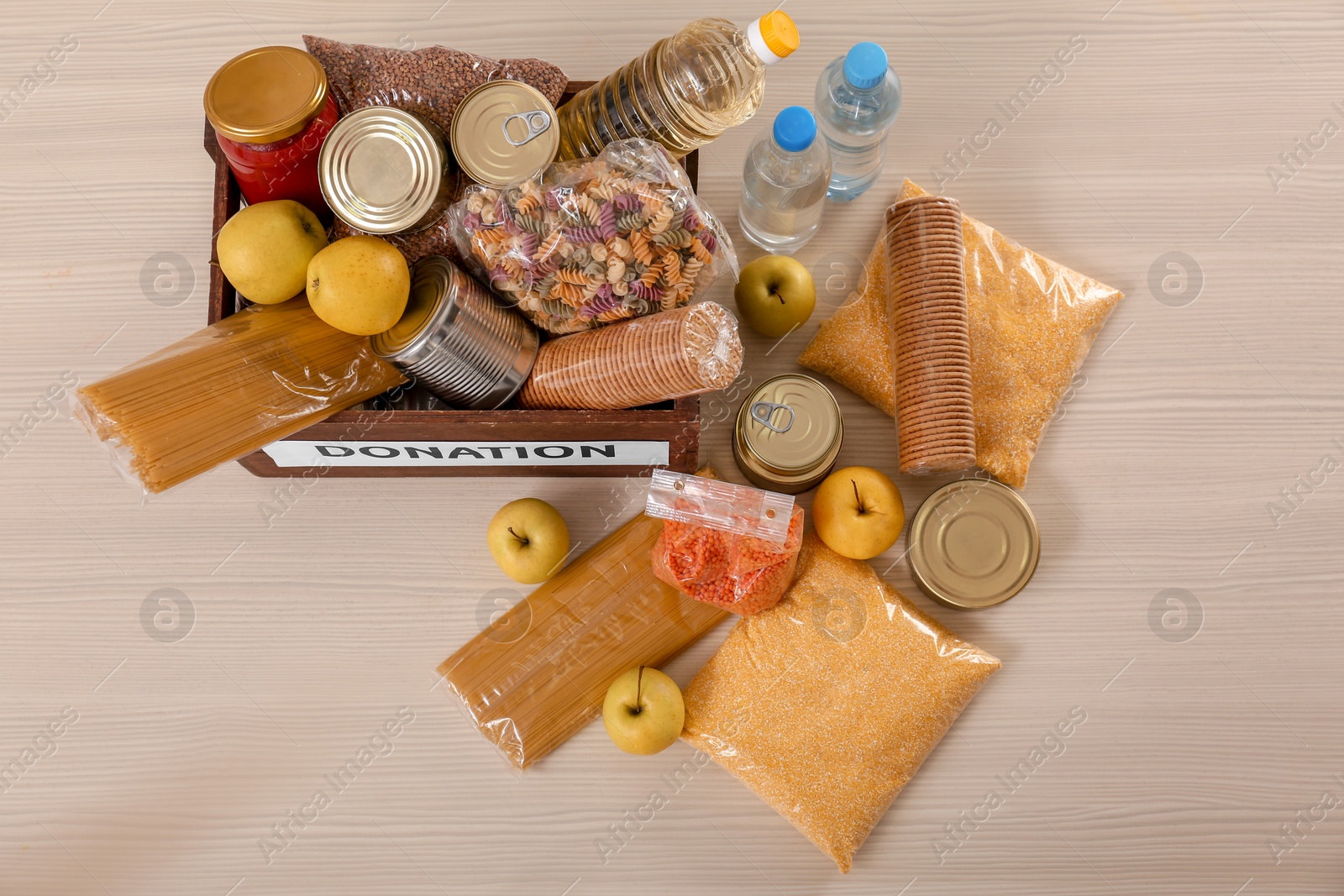 Photo of Donation box and different products on wooden table, top view