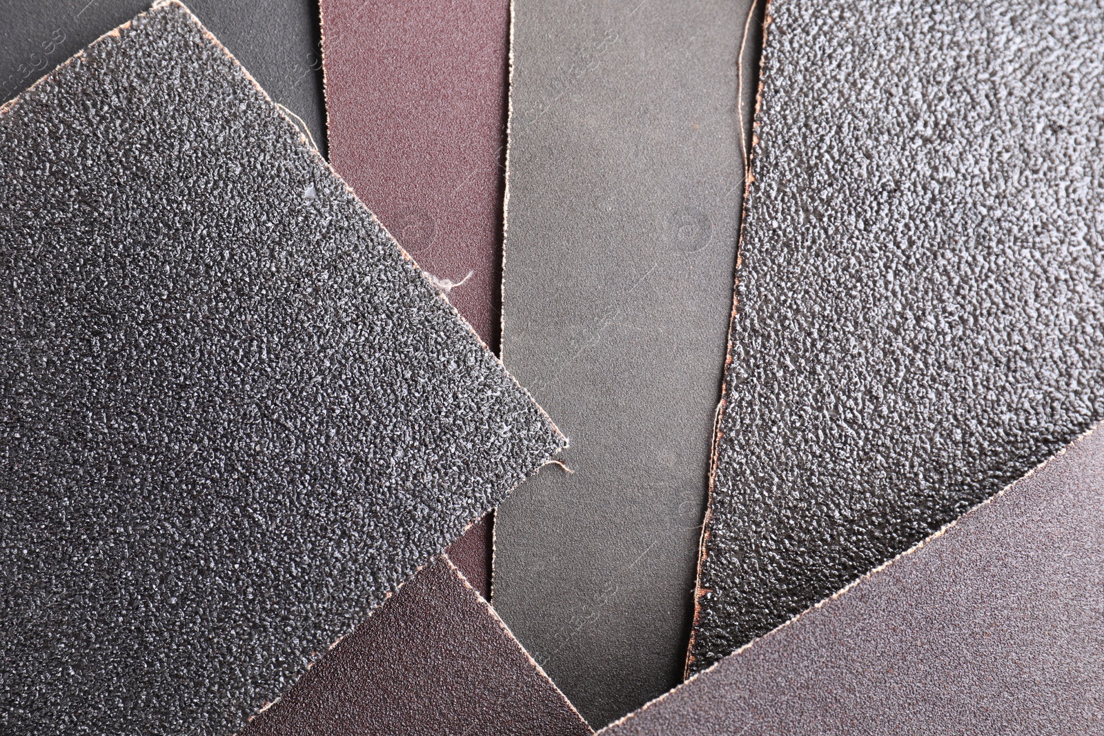 Photo of Many sheets of sandpaper as background, top view