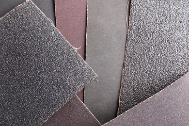 Photo of Many sheets of sandpaper as background, top view