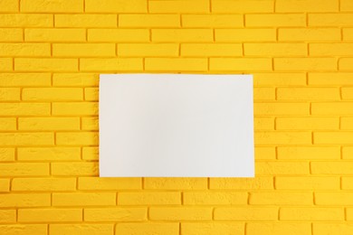 Photo of Blank canvas on yellow brick wall. Space for design