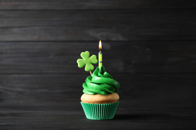 Decorated cupcake on black wooden table. St. Patrick's Day celebration