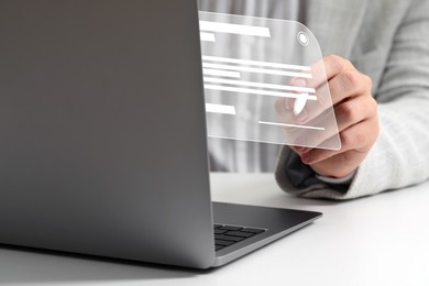 Man signing electronic document via virtual screen over laptop at table, closeup