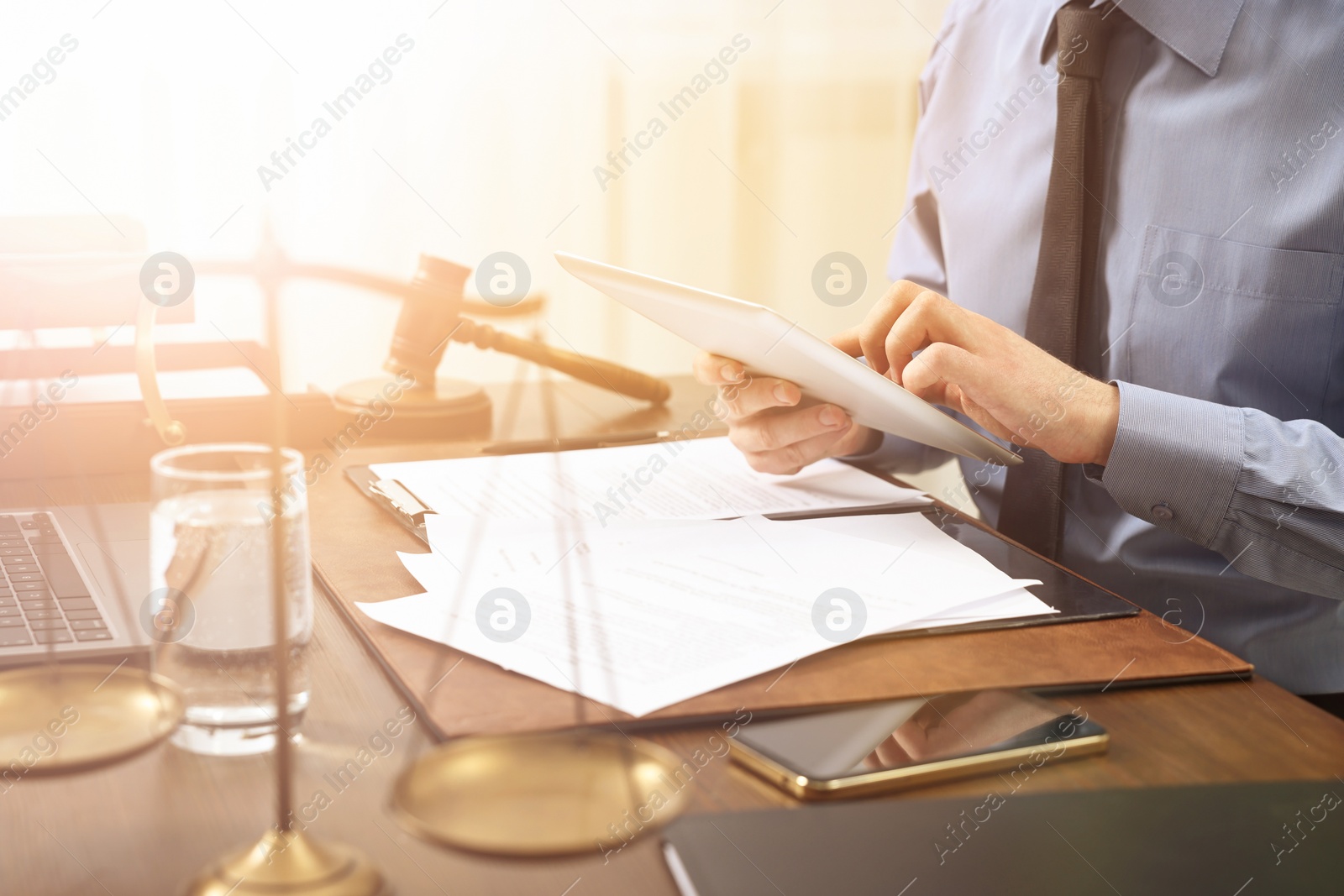 Image of Lawyer using tablet at wooden table, closeup