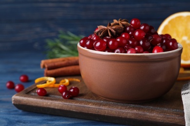 Fresh ripe cranberries and spices on blue wooden table