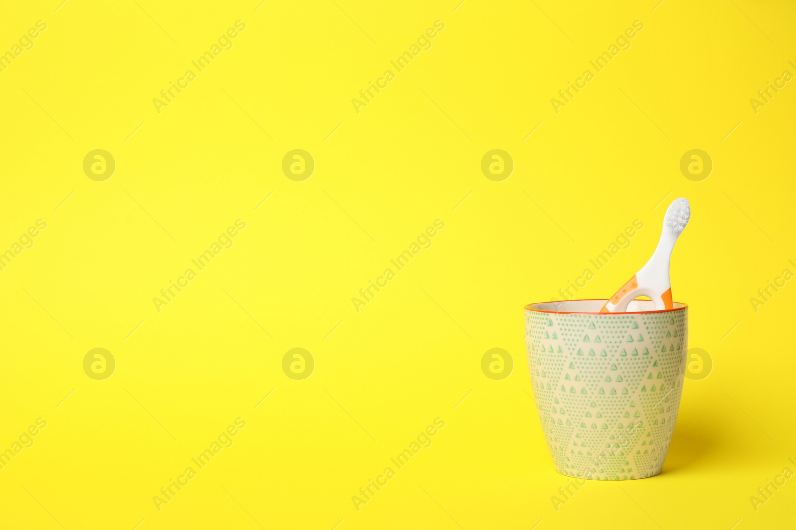 Photo of Baby toothbrush in holder and space for text on color background