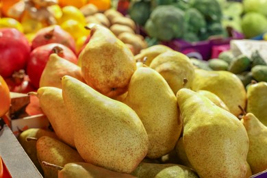 Photo of Pears and other fresh fruits on counter at market, closeup