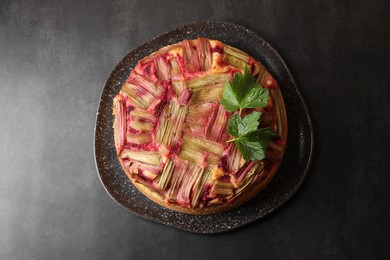 Photo of Freshly baked rhubarb pie on black table, top view