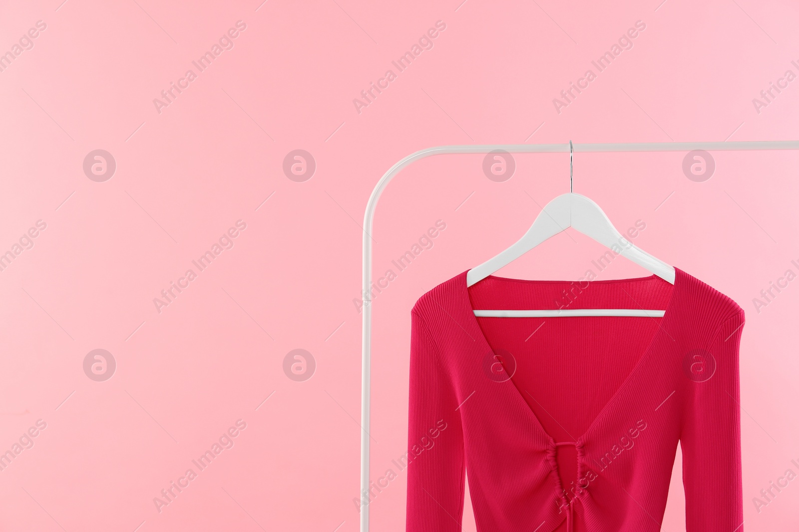 Photo of Rack with stylish woman's top on pink background. Space for text