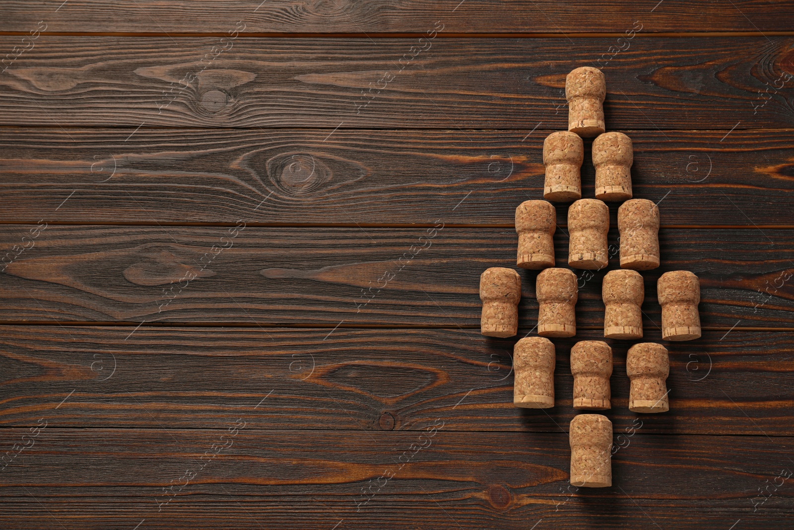 Photo of Christmas tree made of wine corks on wooden table, top view. Space for text