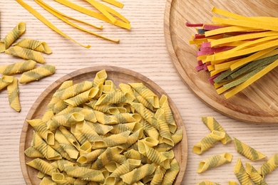 Flat lay composition with different types of pasta on wooden background
