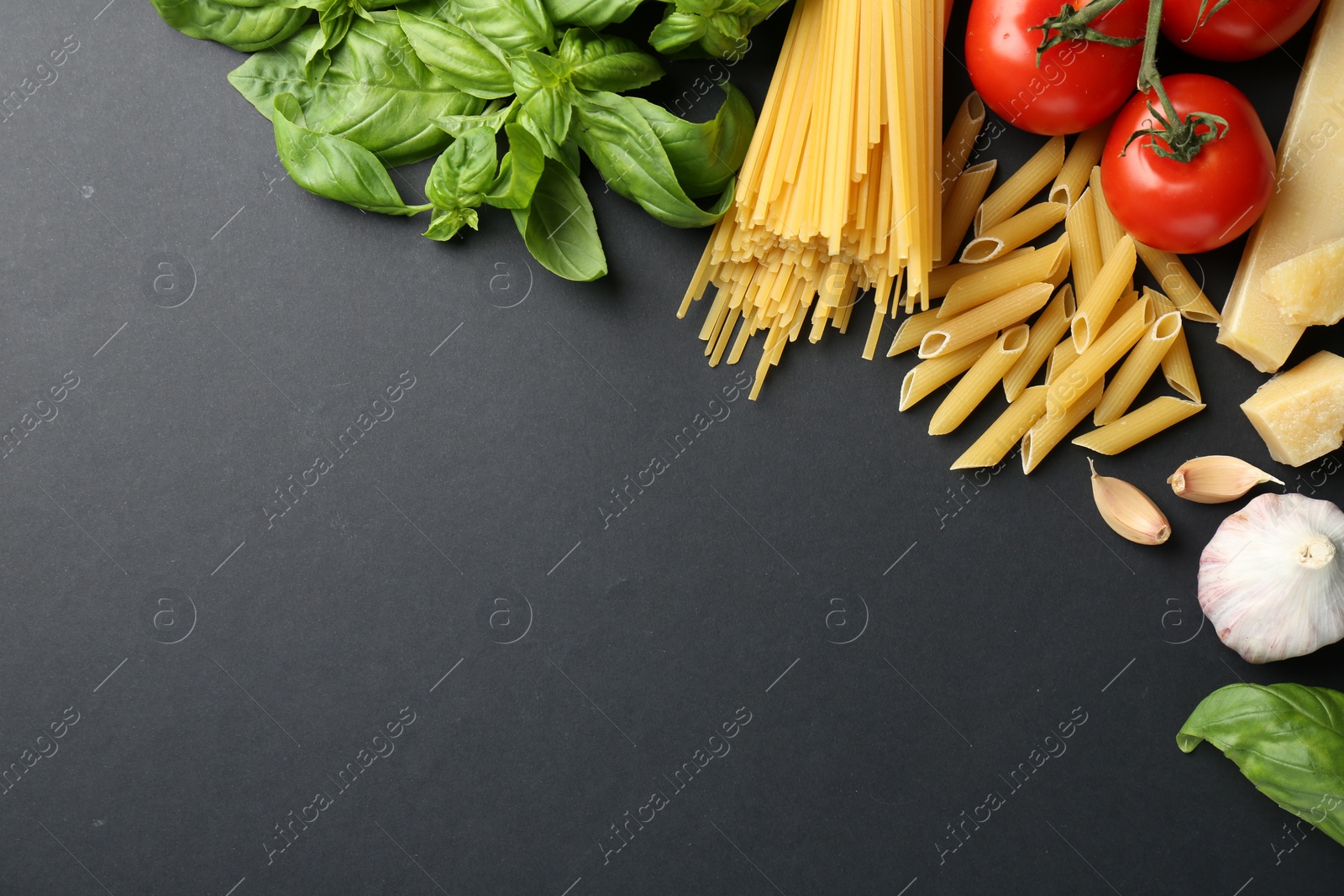 Photo of Different types of pasta, spices and products on black background, flat lay. Space for text