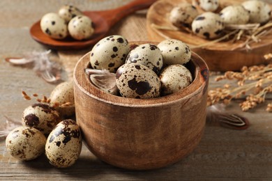 Photo of Bowl and quail eggs on wooden table