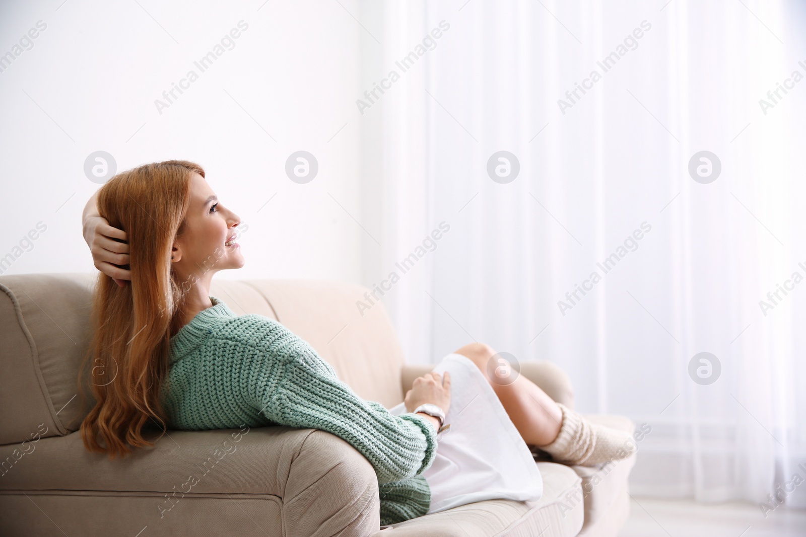 Photo of Young woman relaxing on couch at home. Space for text