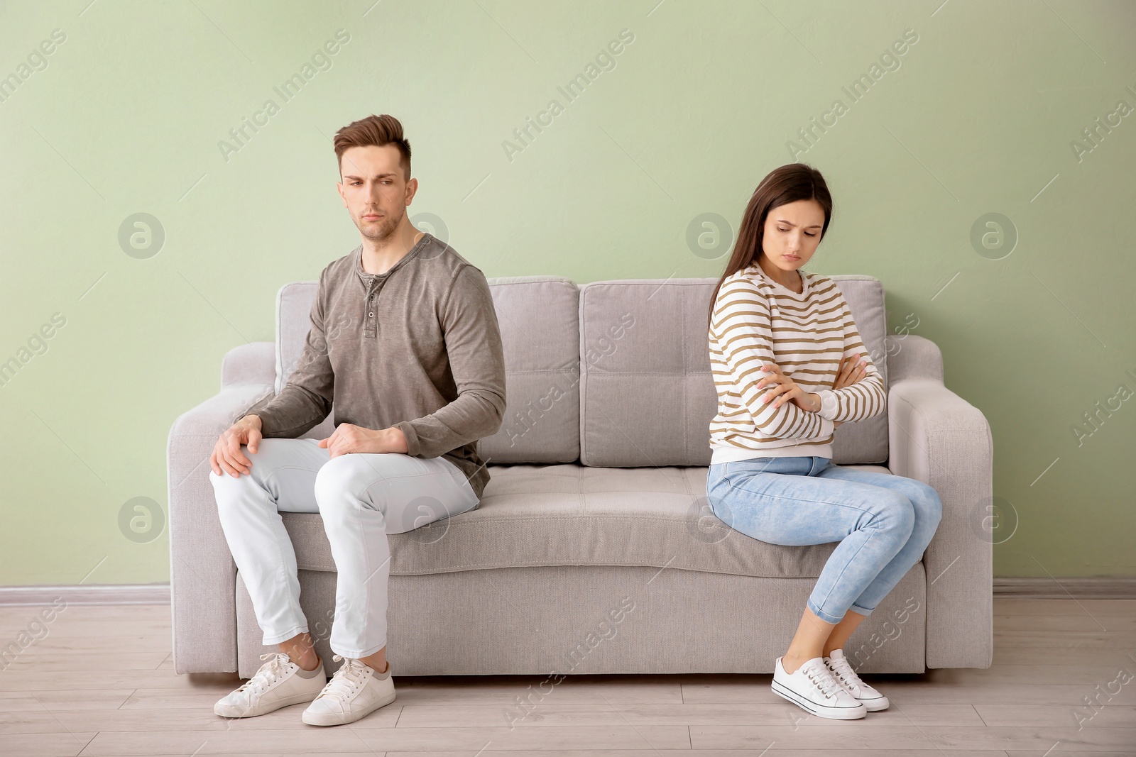 Photo of Young couple sitting on sofa, indoors