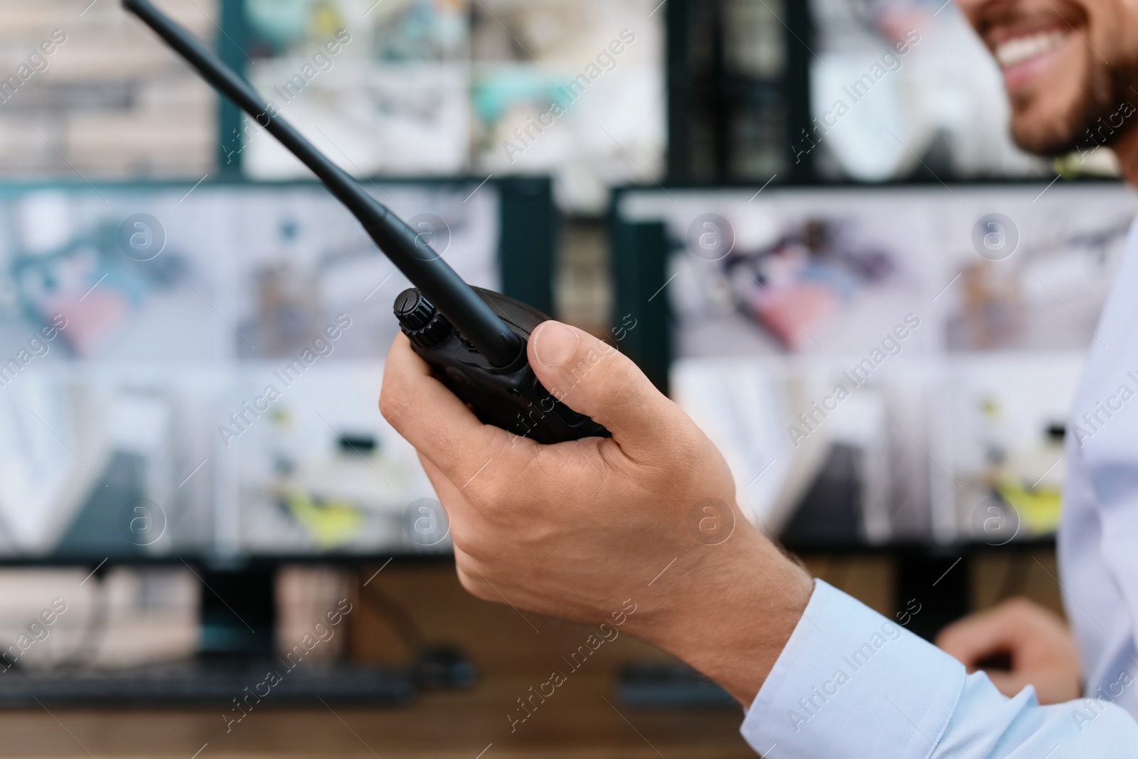 Photo of Male security guard with portable transmitter at workplace, closeup. CCTV surveillance