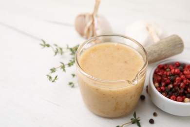 Photo of Delicious turkey gravy, thyme and peppercorns on white table, closeup. Space for text