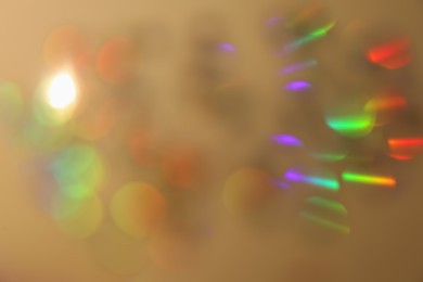 Photo of Blurred view of shiny lights on beige background. Bokeh effect