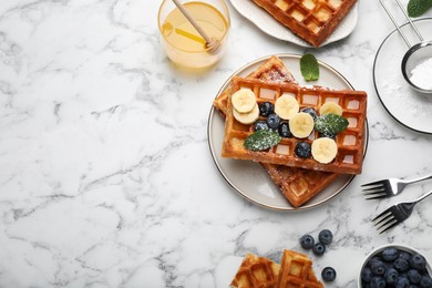 Photo of Delicious Belgian waffles and ingredients on white marble table, flat lay. Space for text