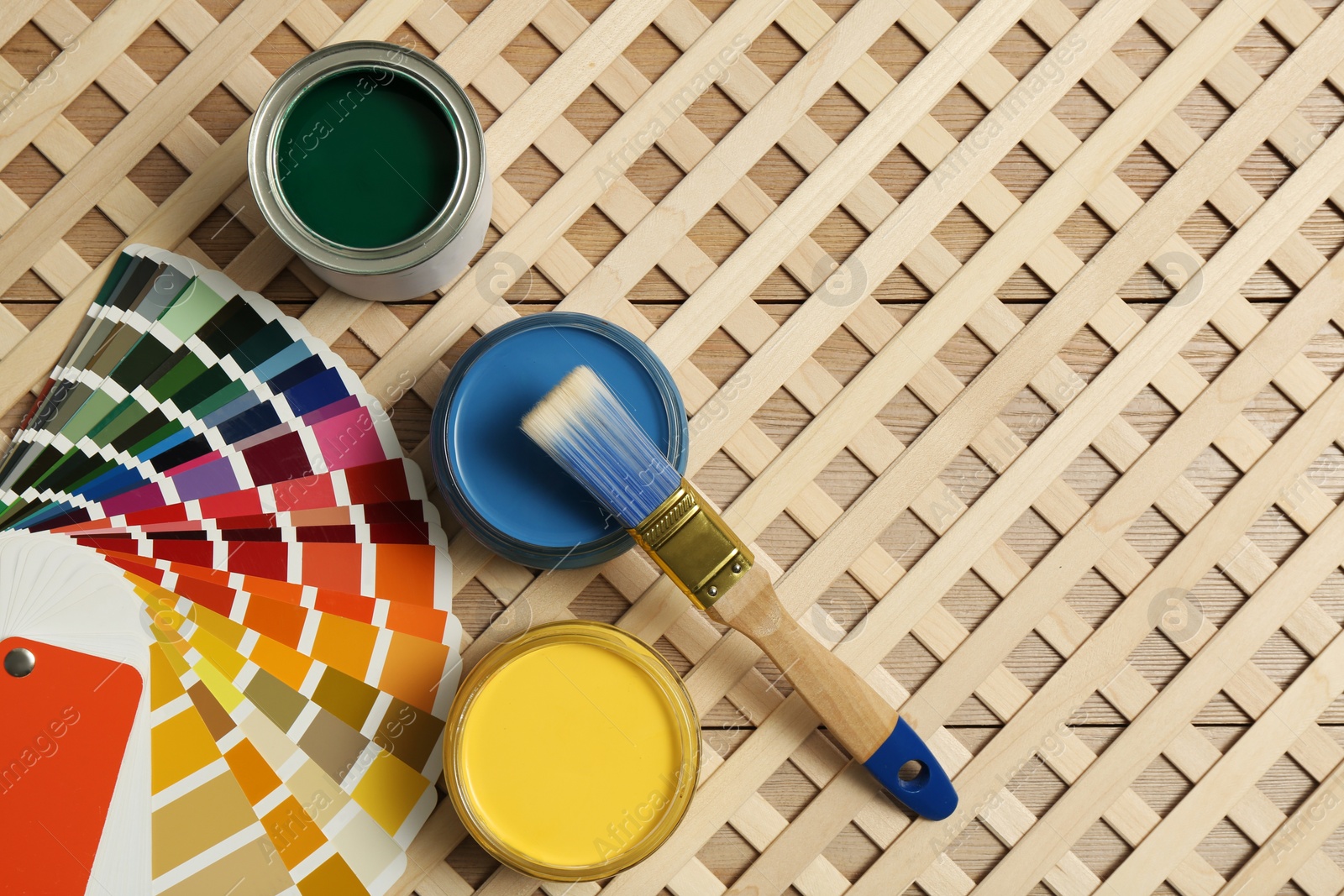 Photo of Different paints with brush and palette on wooden background, flat lay. Space for text