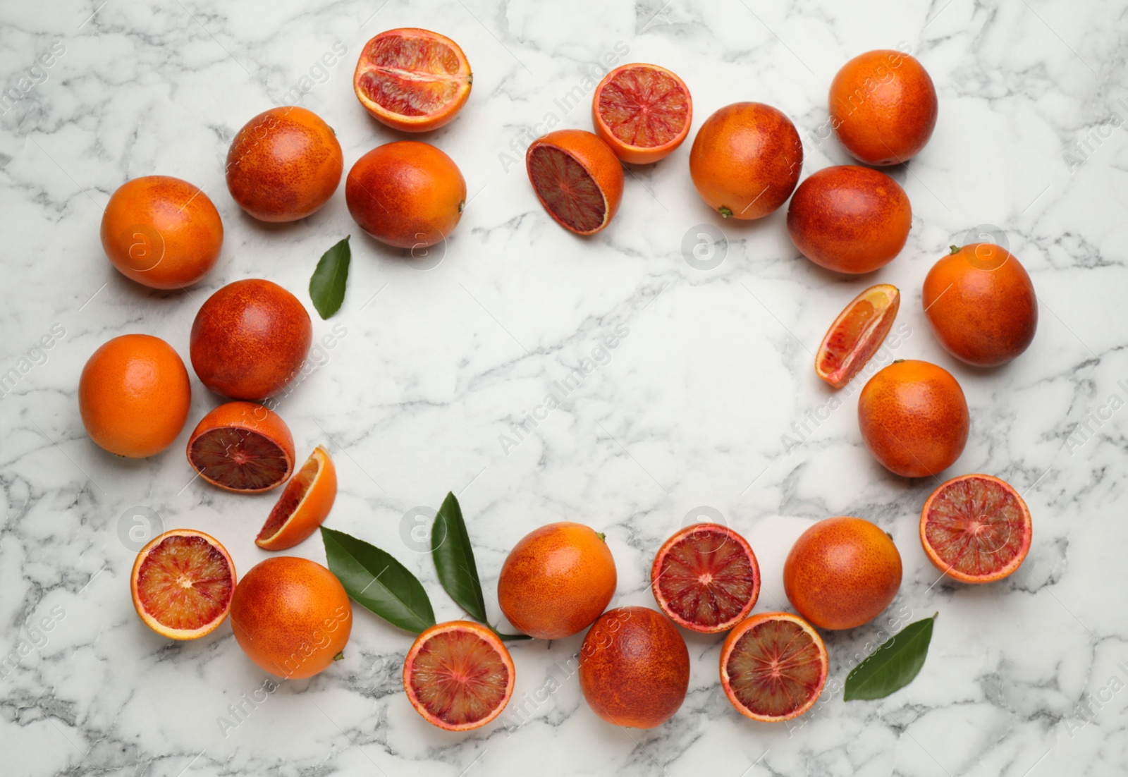 Photo of Frame of ripe sicilian oranges and leaves on white marble table, flat lay. Space for text