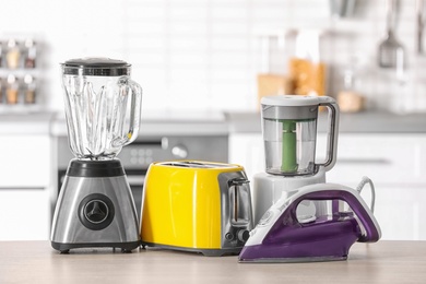 Photo of Household and kitchen appliances on table against blurred background