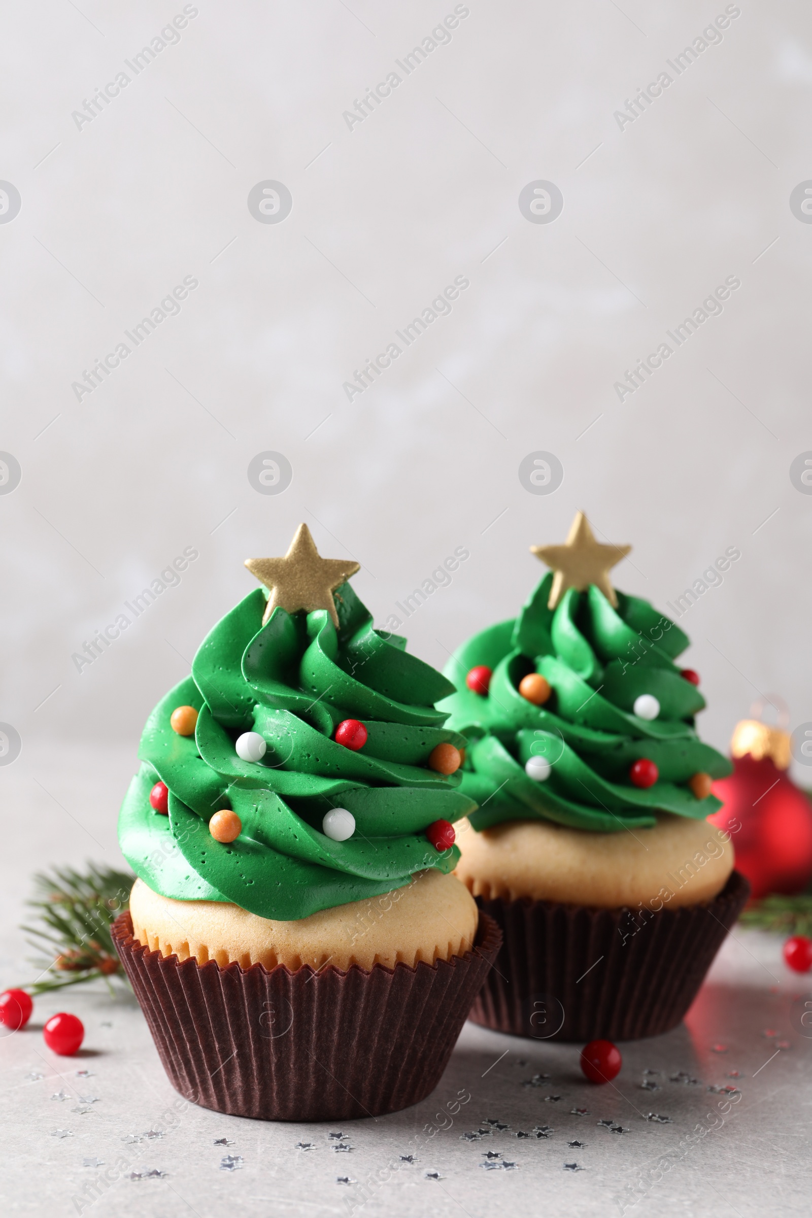 Photo of Christmas tree shaped cupcakes on light grey table