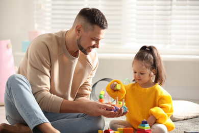 Photo of Father playing with his child at home