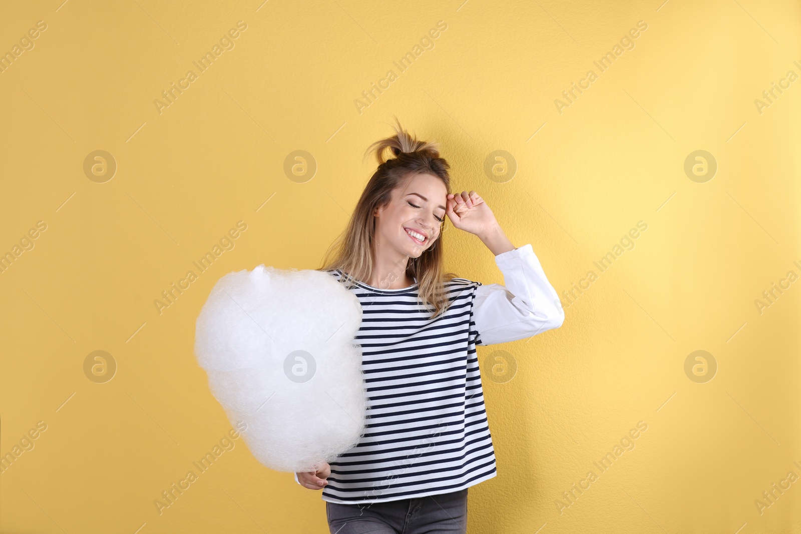 Photo of Young pretty woman with cotton candy on colorful background