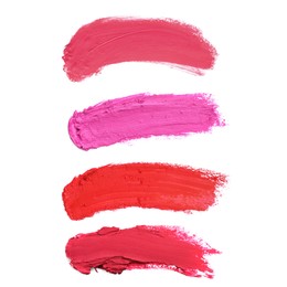 Smears of different beautiful lipsticks on white background, top view