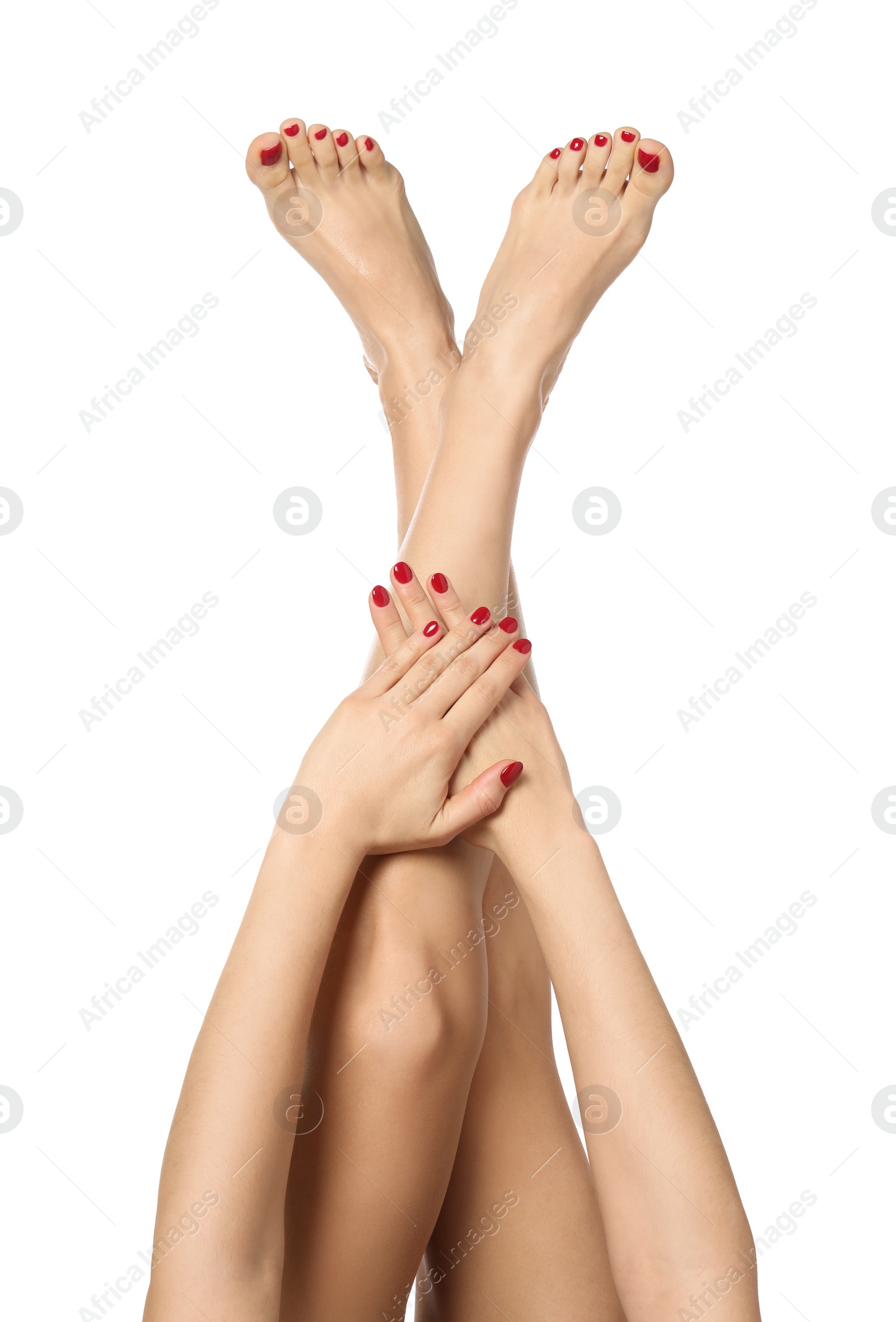 Photo of Woman showing stylish toenails after pedicure procedure and manicured hands with red nail polish isolated on white, closeup