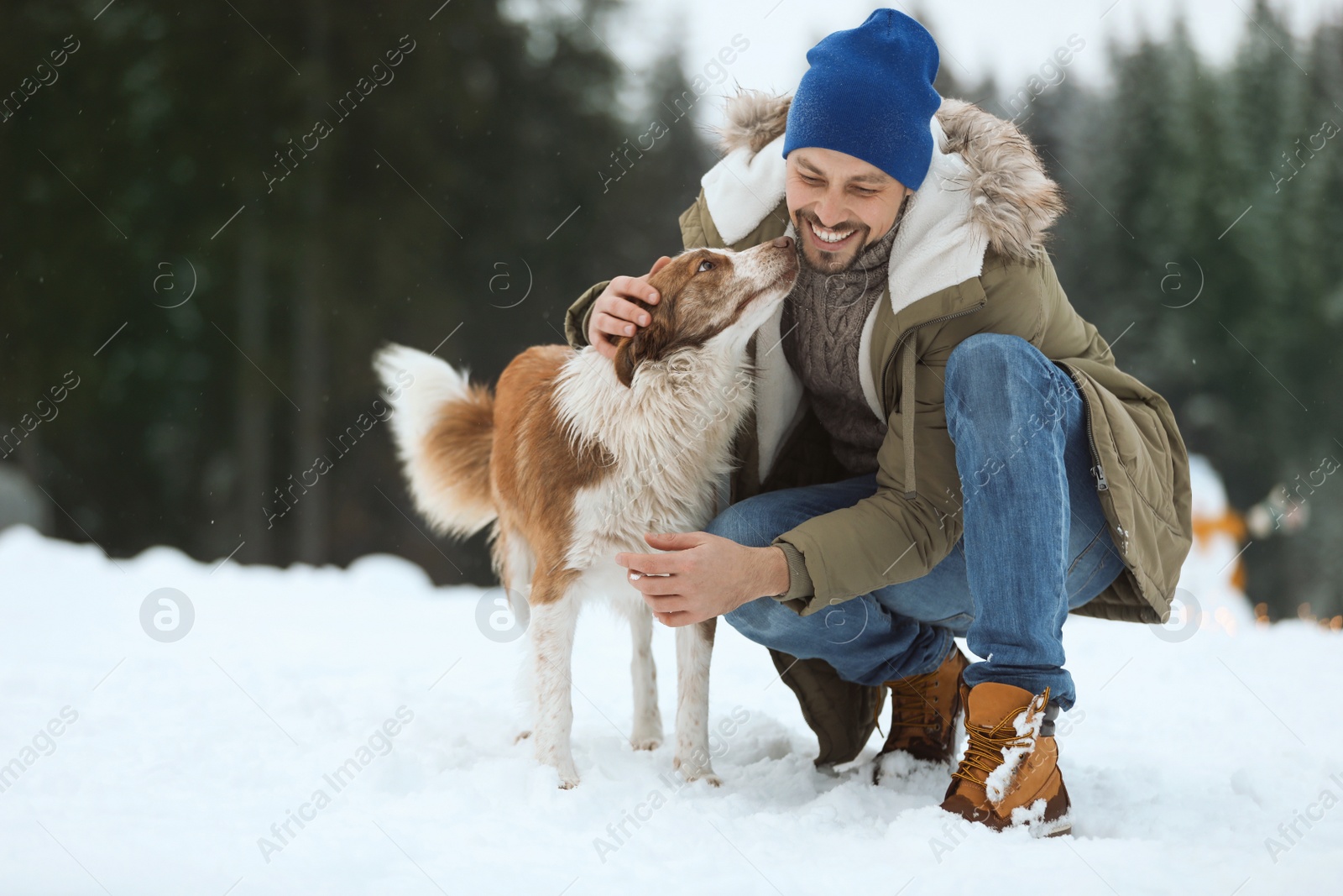 Photo of Man with cute dog near forest. Winter vacation