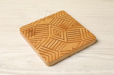Stylish cup coaster on white wooden table, closeup