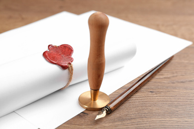 Notary's public pen and document with wax stamp on wooden table, closeup