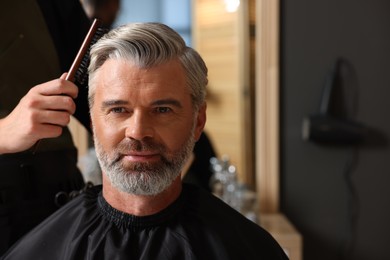 Photo of Hair styling. Professional hairdresser working with client in barbershop, closeup