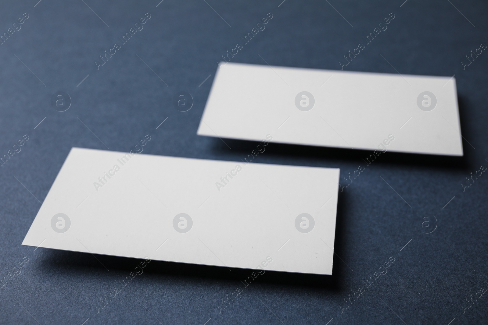 Photo of Blank business cards on dark grey background, closeup. Mock up for design