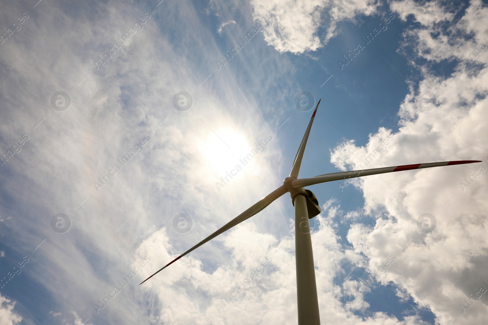 Photo of Modern wind turbine against cloudy sky, low angle view. Alternative energy source