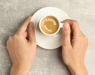 Image of Coffee Break. Woman with cup of espresso at grey table, top view
