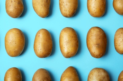 Flat lay composition with fresh ripe organic potatoes on color background