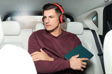 Photo of Handsome man listening to audiobook in car